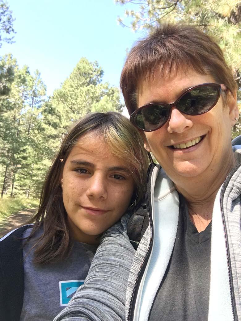 This is a photo of Mia and Jeri, New Pathways for Youth mentee and mentor. This photo was captured outdoors surrounded by trees.